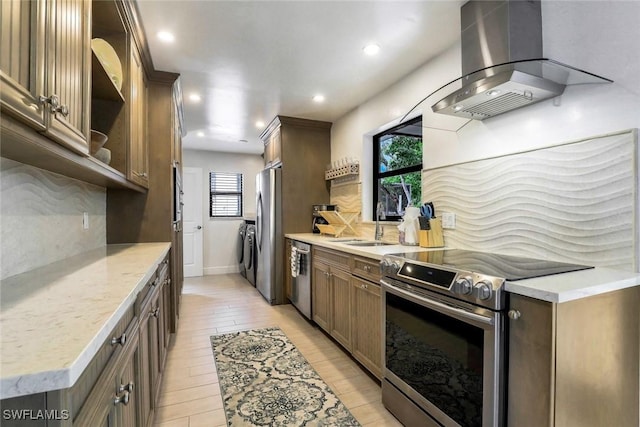 387 S Heathwood Dr, Marco Island, FL 34145 - kitchen with washer and dryer, wall chimney range hood, stainless steel appliances, and backsplash