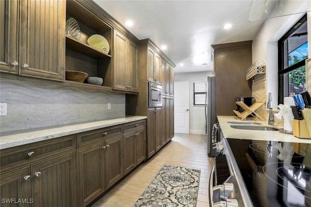 387 S Heathwood Dr, Marco Island, FL 34145 - kitchen with light wood-style flooring, a sink, open shelves, stainless steel appliances, and tasteful backsplash