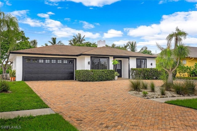 387 S Heathwood Dr, Marco Island, FL 34145 - ranch-style home with stucco siding, decorative driveway, and a garage