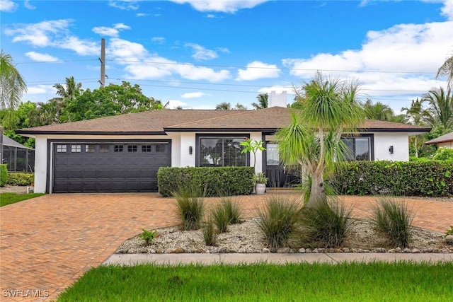 387 S Heathwood Dr, Marco Island, FL 34145 - ranch-style house featuring a garage, stucco siding, a chimney, decorative driveway, and roof with shingles