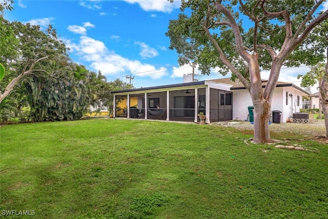 387 S Heathwood Dr, Marco Island, FL 34145 - back of property with stucco siding, ceiling fan, a chimney, a lawn, and a sunroom