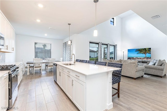 18707 Ivywood Pl, Estero, FL 33928 - kitchen with a kitchen breakfast bar, light wood-style flooring, visible vents, a sink, and stainless steel appliances
