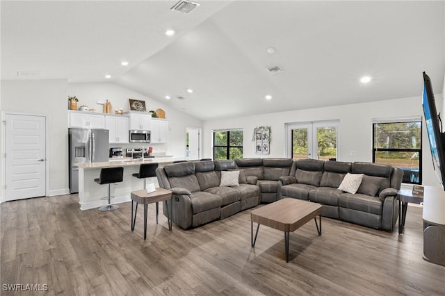 490 Windermere Dr, Lehigh Acres, FL 33972 - living room featuring visible vents, wood finished floors, and vaulted ceiling