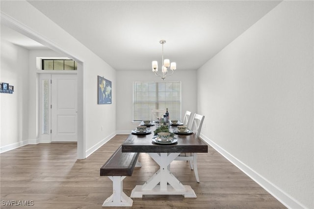 490 Windermere Dr, Lehigh Acres, FL 33972 - dining area with baseboards, a wealth of natural light, wood finished floors, and an inviting chandelier