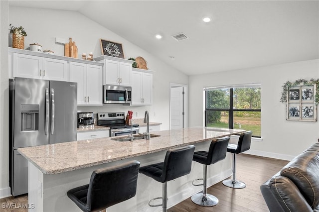 490 Windermere Dr, Lehigh Acres, FL 33972 - kitchen with white cabinetry, stainless steel appliances, a breakfast bar, a sink, and visible vents