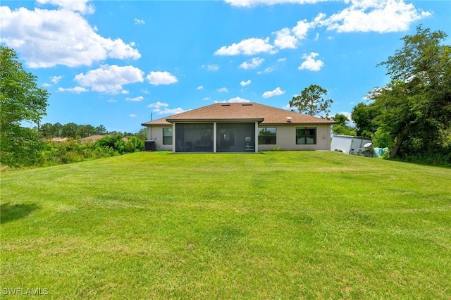 490 Windermere Dr, Lehigh Acres, FL 33972 - back of property featuring cooling unit, a sunroom, stucco siding, and a lawn