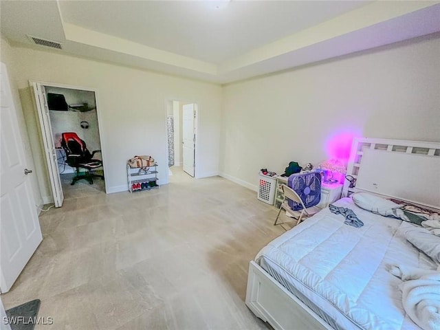 bedroom featuring baseboards, visible vents, and a raised ceiling