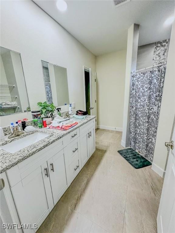 bathroom with double vanity, a sink, a shower with shower curtain, and visible vents