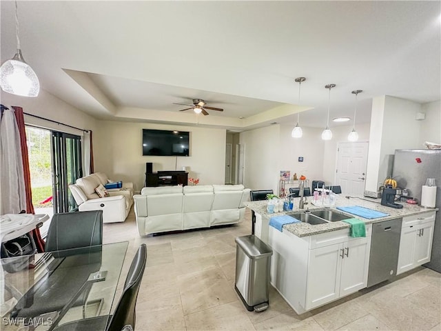 kitchen featuring white cabinetry, a tray ceiling, a sink, and dishwasher