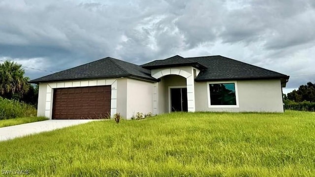 3214 34th St W, Lehigh Acres, FL 33971 - view of front facade with an attached garage, driveway, stucco siding, a front lawn, and roof with shingles