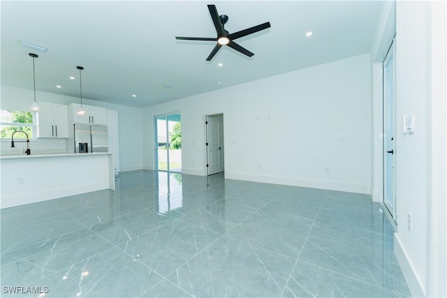 5308 4th St W, Lehigh Acres, FL 33971 - unfurnished living room featuring ceiling fan, recessed lighting, a sink, baseboards, and light marble finish floors