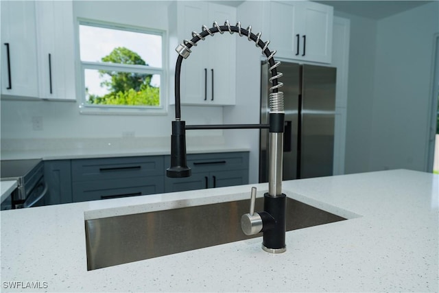 5308 4th St W, Lehigh Acres, FL 33971 - kitchen featuring light stone counters, white cabinets, range, and a sink