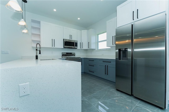 5308 4th St W, Lehigh Acres, FL 33971 - kitchen with appliances with stainless steel finishes, open shelves, a peninsula, a sink, and white cabinetry