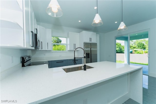 5308 4th St W, Lehigh Acres, FL 33971 - kitchen with appliances with stainless steel finishes, a sink, white cabinetry, a peninsula, and pendant lighting