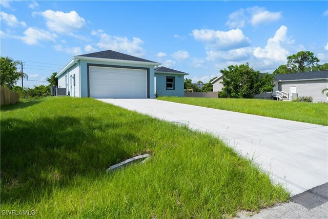 5308 4th St W, Lehigh Acres, FL 33971 - view of front of house featuring concrete driveway, a front yard, a garage, and stucco siding