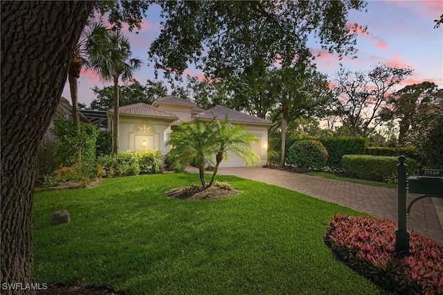 27549 Riverbank Dr, Bonita Springs, FL 34134 - mediterranean / spanish-style house with a garage, a tile roof, stucco siding, a front lawn, and driveway