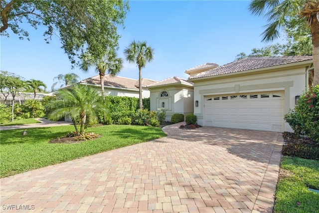 27549 Riverbank Dr, Bonita Springs, FL 34134 - mediterranean / spanish home with a front yard, a garage, a tile roof, stucco siding, and decorative driveway