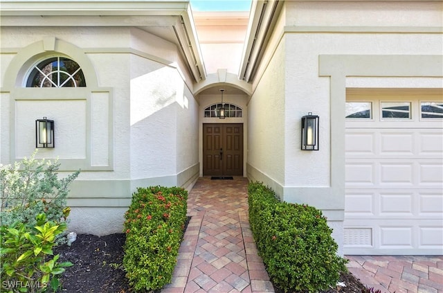 27549 Riverbank Dr, Bonita Springs, FL 34134 - view of exterior entry featuring a garage and stucco siding