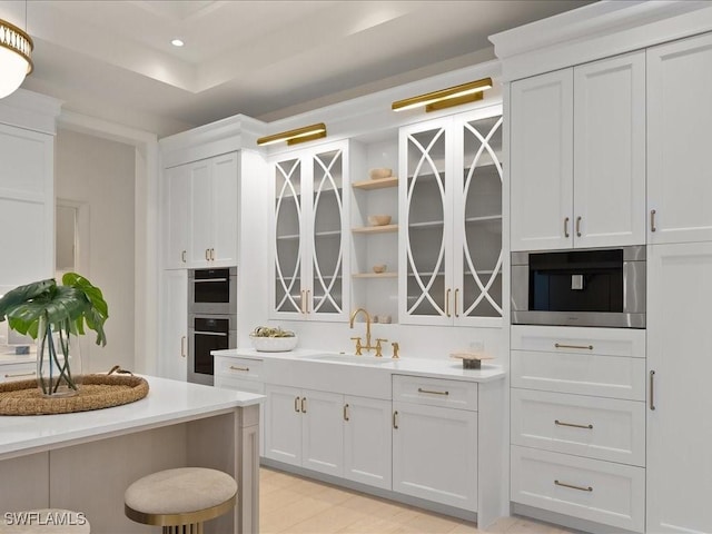 619 Binnacle Dr, Naples, FL 34103 - kitchen featuring light countertops, a sink, white cabinetry, double oven, and recessed lighting