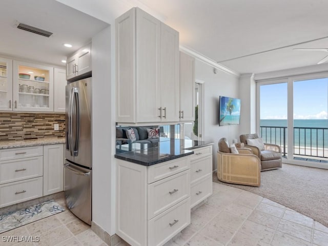140 Seaview Ct Unit 1703N, Marco Island, FL 34145 - kitchen featuring freestanding refrigerator, tasteful backsplash, open floor plan, glass insert cabinets, and stone tile floors