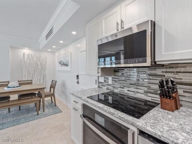 140 Seaview Ct Unit 1703N, Marco Island, FL 34145 - kitchen with stainless steel appliances, crown molding, white cabinets, tasteful backsplash, and light stone counters