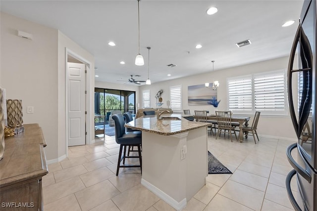 kitchen featuring light tile patterned flooring, visible vents, a ceiling fan, and freestanding refrigerator
