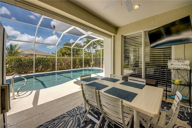 view of pool with glass enclosure, a fenced in pool, a ceiling fan, outdoor dining space, and a patio