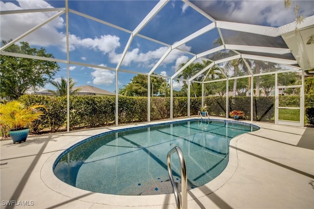 view of pool featuring glass enclosure, a patio, and a fenced in pool