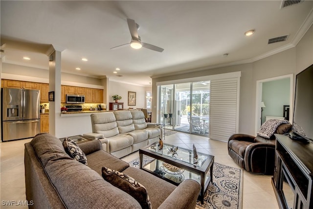 living room featuring ornamental molding, light tile patterned flooring, visible vents, and ceiling fan
