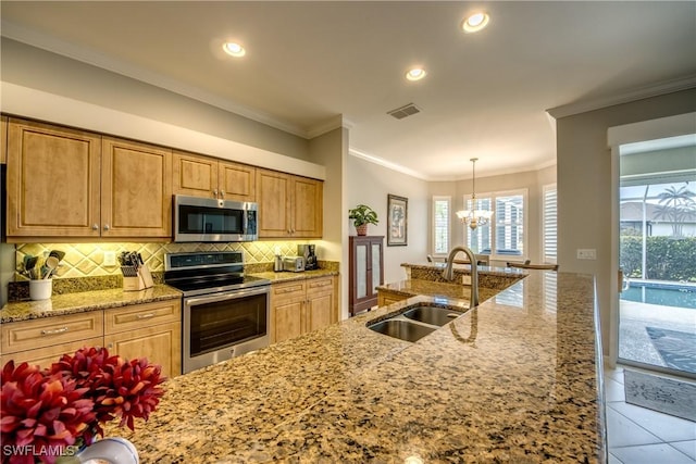 kitchen featuring stainless steel appliances, a sink, decorative backsplash, light stone countertops, and ornamental molding
