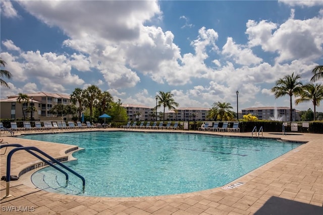 community pool with fence and a patio area