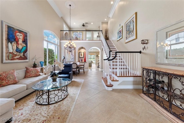living room featuring stairs, a high ceiling, arched walkways, and a wealth of natural light