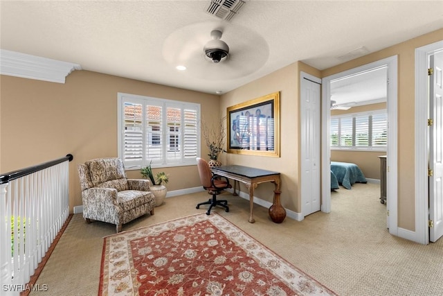 carpeted home office featuring baseboards, a textured ceiling, ceiling fan, and visible vents