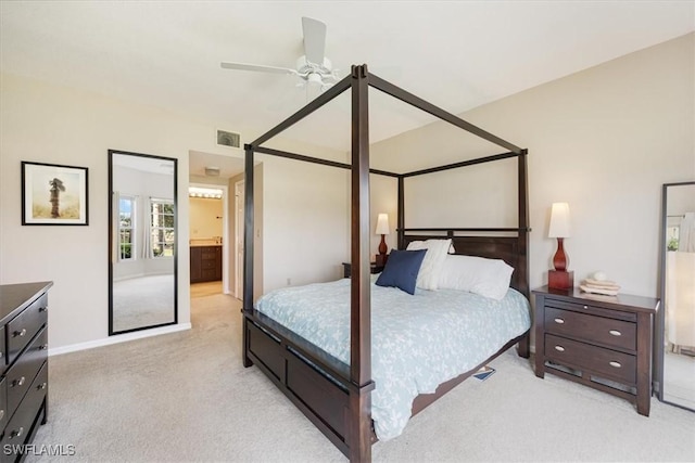 6025 Chardonnay Ln Unit 103, Naples, FL 34119 - bedroom featuring baseboards, visible vents, light colored carpet, a ceiling fan, and connected bathroom