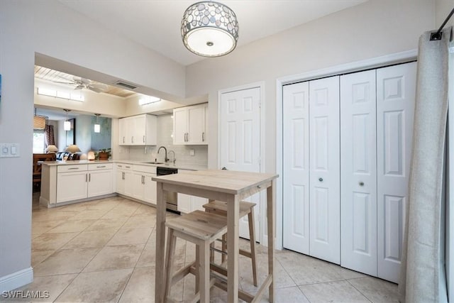 6025 Chardonnay Ln Unit 103, Naples, FL 34119 - kitchen featuring a sink, light tile patterned floors, light countertops, white cabinets, and visible vents