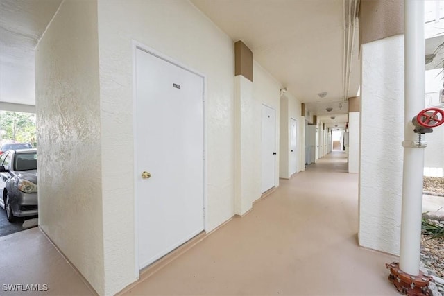 6025 Chardonnay Ln Unit 103, Naples, FL 34119 - hallway featuring a textured wall and concrete floors
