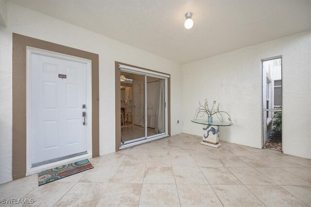 6025 Chardonnay Ln Unit 103, Naples, FL 34119 - view of exterior entry with stucco siding and a patio area