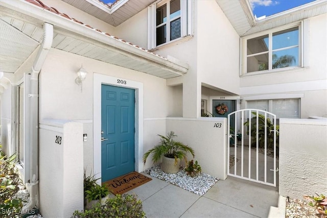 5045 Cedar Springs Dr Unit 203, Naples, FL 34110 - property entrance with fence, a tiled roof, a gate, and stucco siding