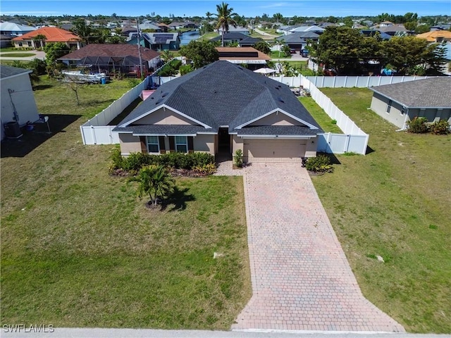 view of front of home with a fenced backyard, decorative driveway, a residential view, and a garage