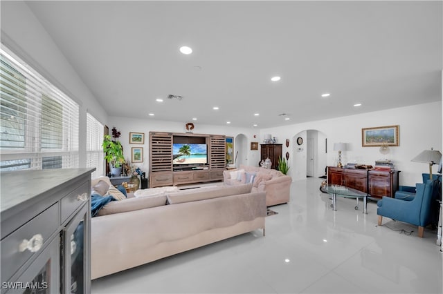 living area featuring visible vents, recessed lighting, arched walkways, and tile patterned flooring
