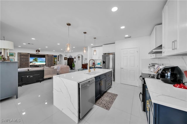 kitchen with under cabinet range hood, a sink, light stone counters, and stainless steel appliances