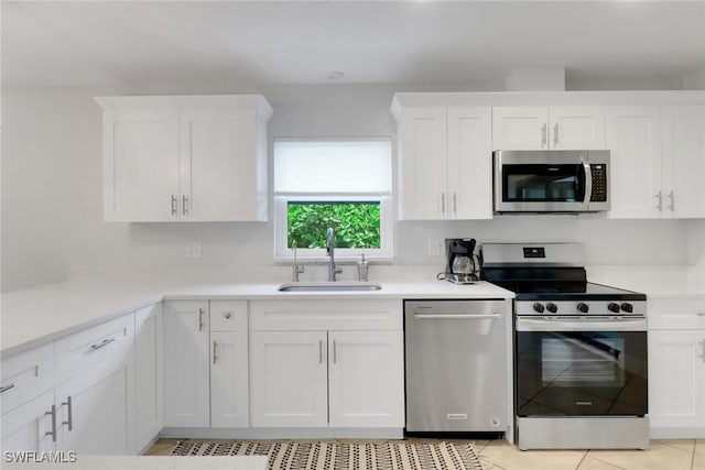 590 104th Ave N, Naples, FL 34108 - kitchen featuring stainless steel appliances, white cabinets, light countertops, and light tile patterned flooring