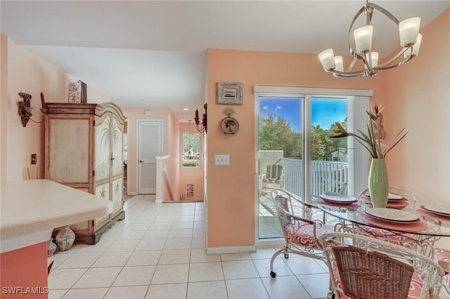 dining area with a chandelier, light tile patterned flooring, and baseboards