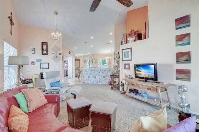 living area featuring a chandelier, a ceiling fan, carpet, high vaulted ceiling, and baseboards