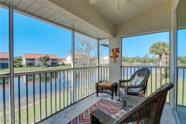 sunroom with a water view, ceiling fan, vaulted ceiling, and a residential view