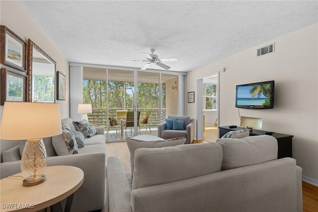 270 Naples Cove Dr Unit 3205, Naples, FL 34110 - living area featuring a textured ceiling, floor to ceiling windows, ceiling fan, visible vents, and wood finished floors