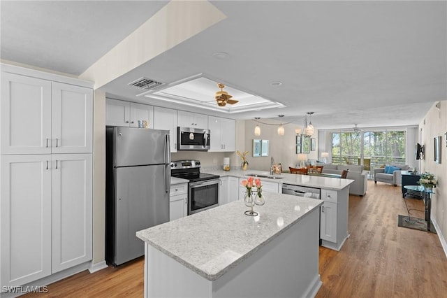 270 Naples Cove Dr Unit 3205, Naples, FL 34110 - kitchen with visible vents, a sink, open floor plan, a peninsula, and appliances with stainless steel finishes