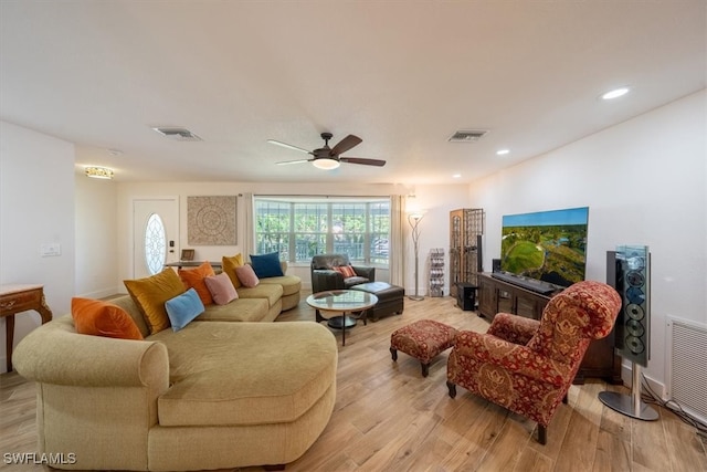 living room featuring light wood-style floors, a ceiling fan, and visible vents