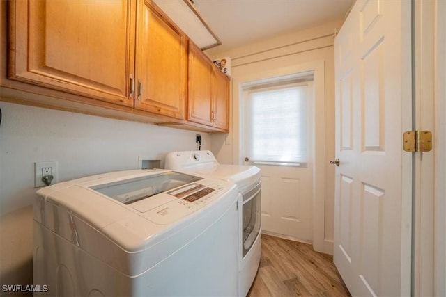laundry area with light wood-style flooring, cabinet space, and washing machine and dryer