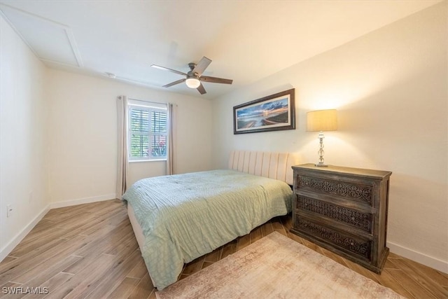 bedroom with baseboards, ceiling fan, and wood finished floors
